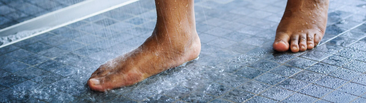 Pies bajo el agua de la ducha Pies bajo el agua de la ducha