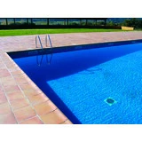 Piscina con gresite azul y jardín al fondo