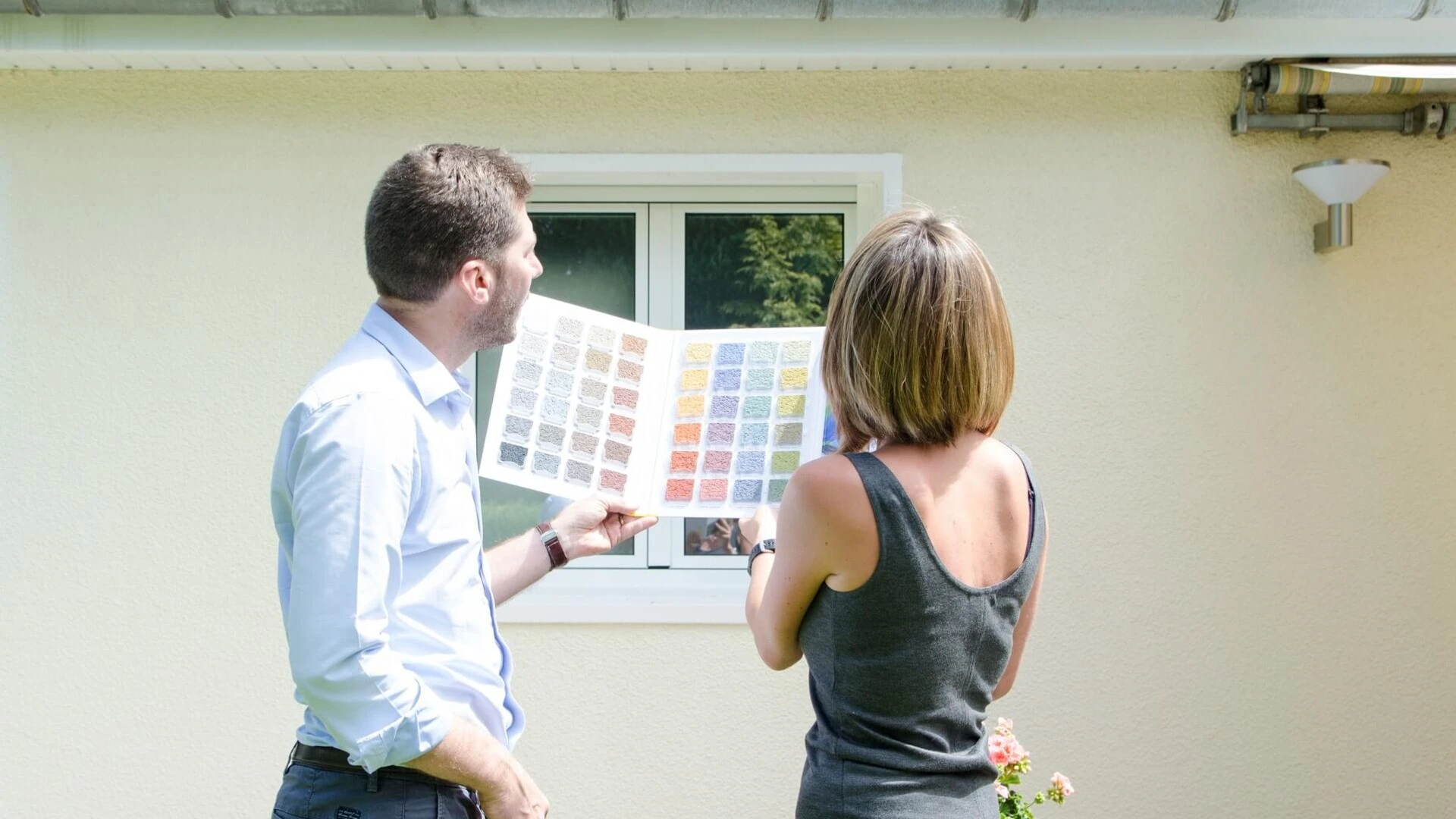 Pareja viendo muestrario con la fachada de su casa