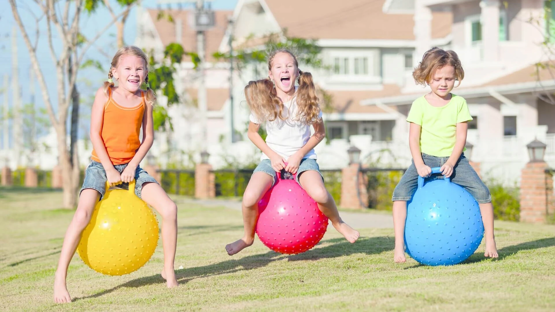 Niñas jugando en el jardín con pelotas de colores Niñas jugando en el jardín con pelotas de colores