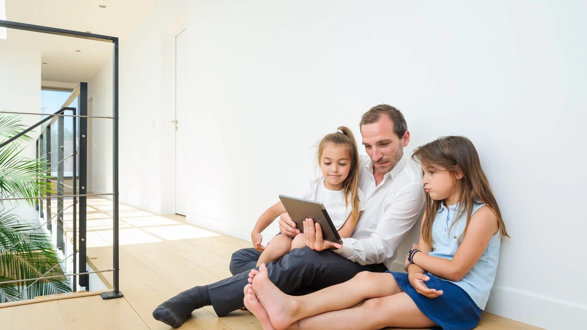 Padre mirando el ipad con las niñas