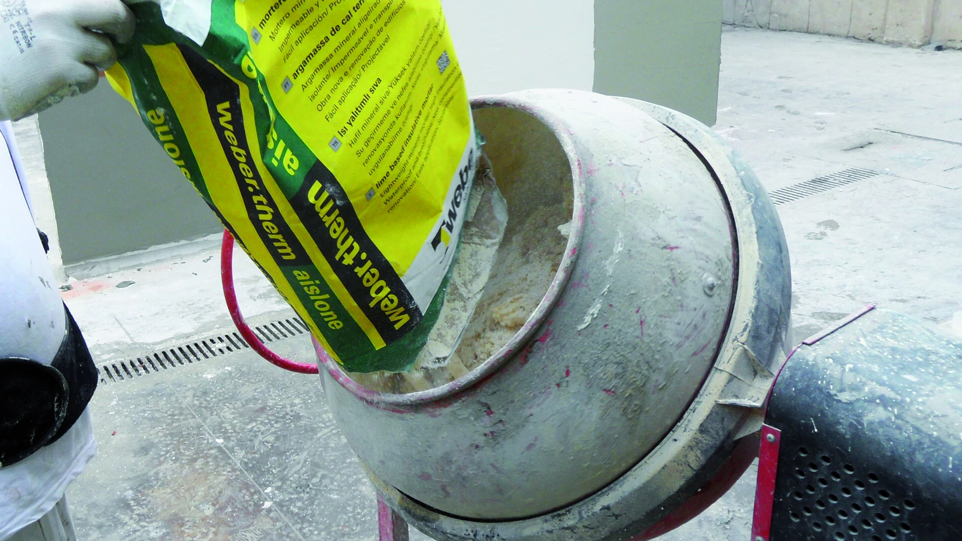 Hombre vertiendo saco en la hormigonera