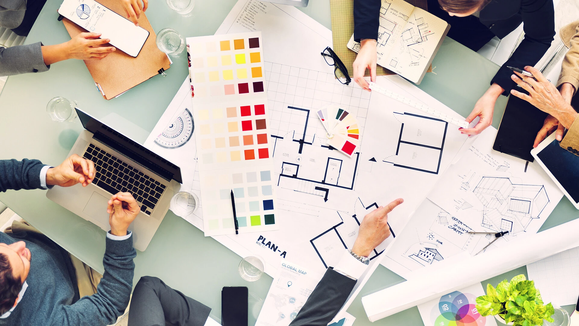 Equipo de gente reunido con mapas encima de la mesa