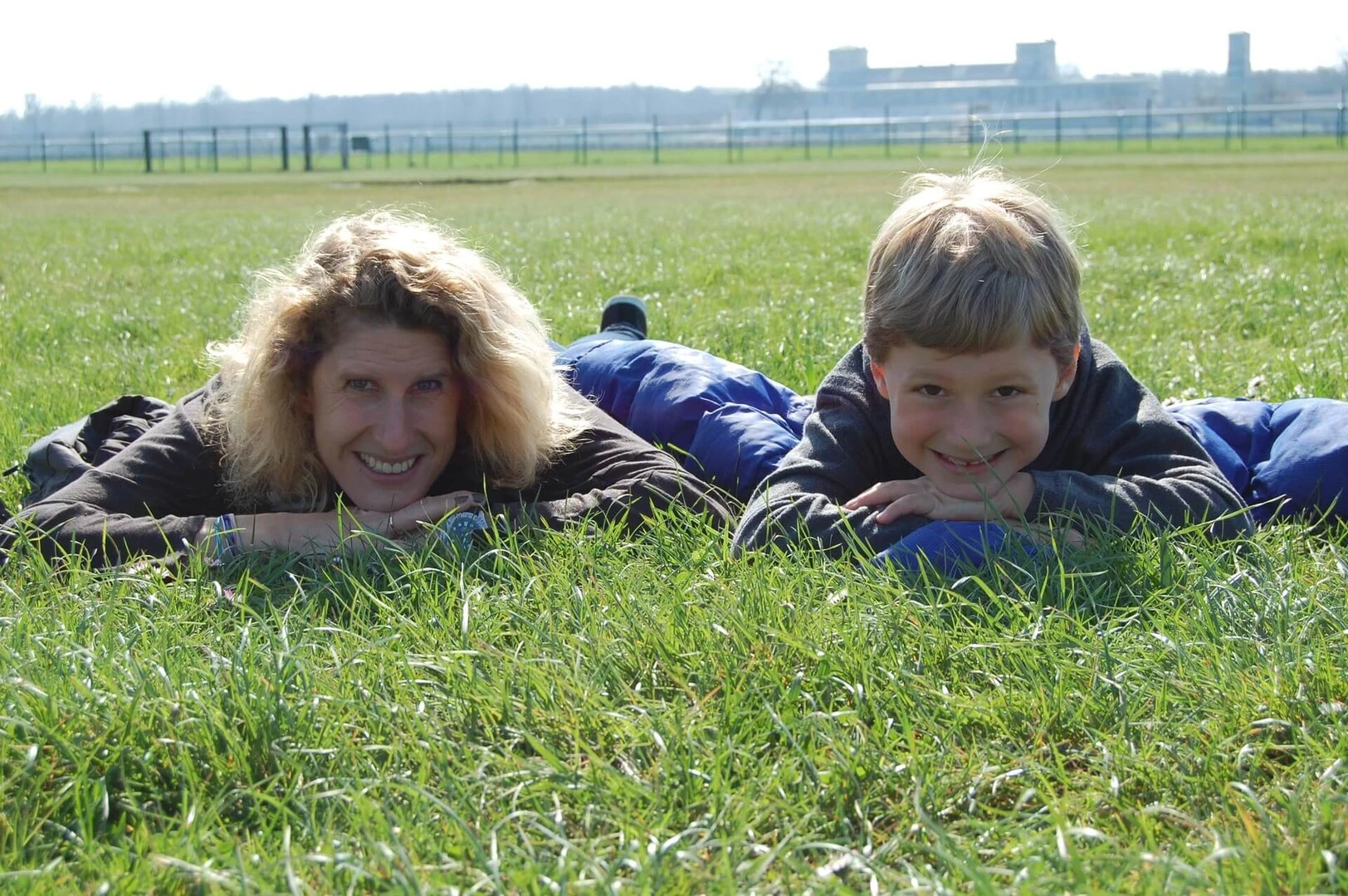Familia tumbada en el exterior sobre hierba