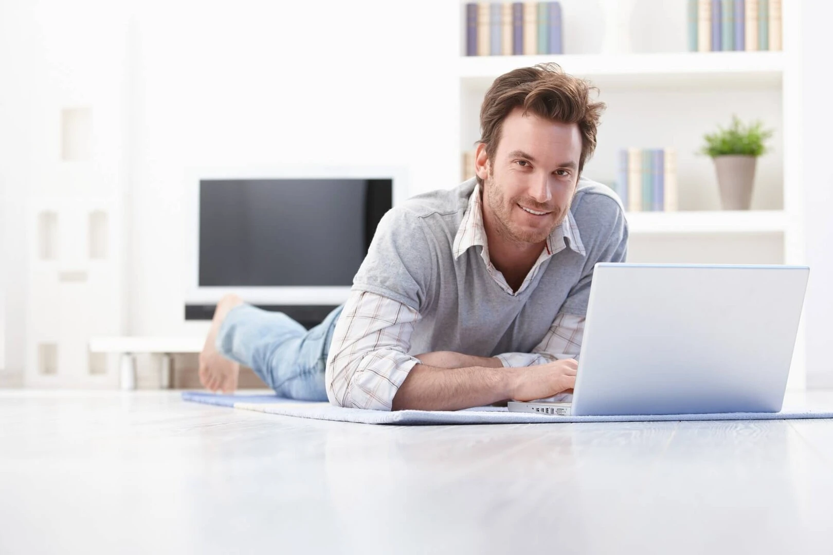 Hombre trabajando con ordenador en el suelo