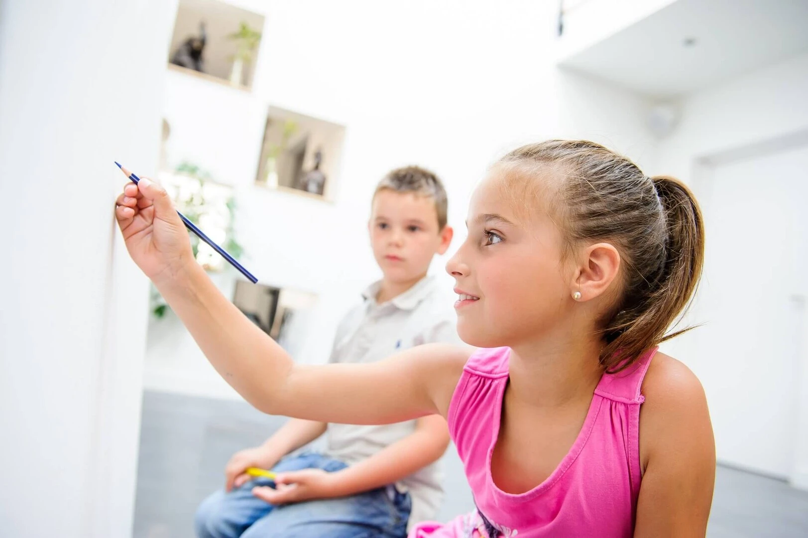 Niños pintando en el interior de una casa las paredes con pincel