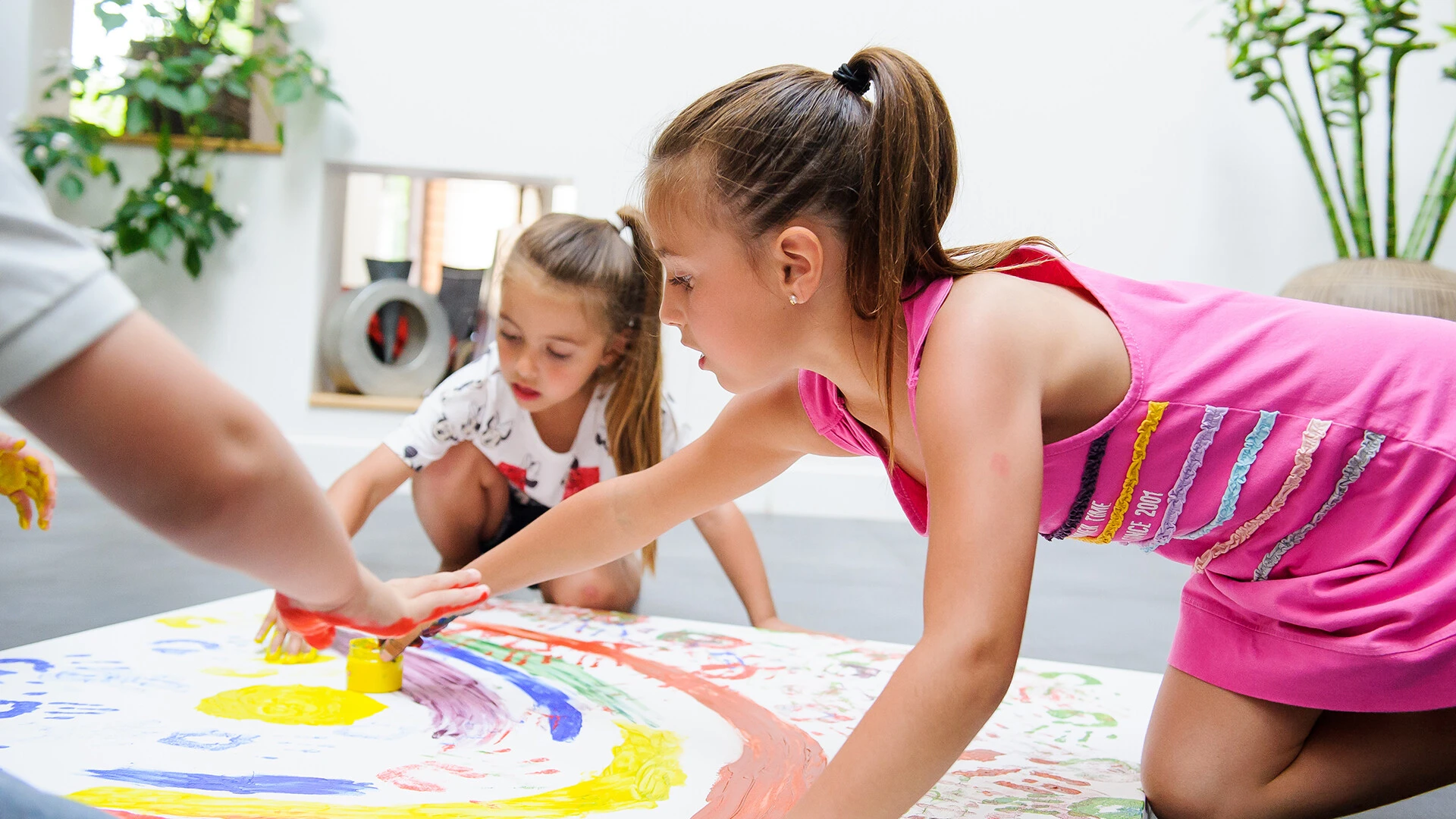Niños pintando en el suelo sobre un papel