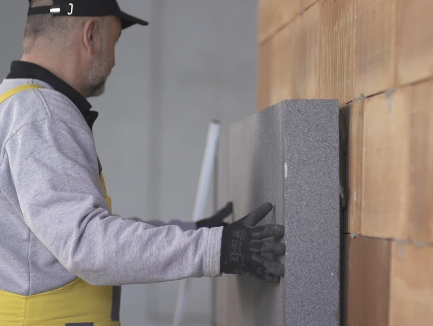 Profesional colocando en fachada placas de EPS Profesional colocando en fachada placas de EPS