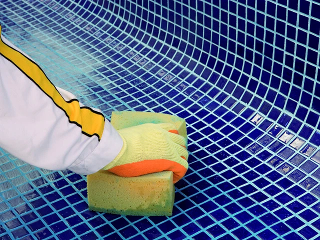 Profesional limpiando la junta de piscina después de la colocación
