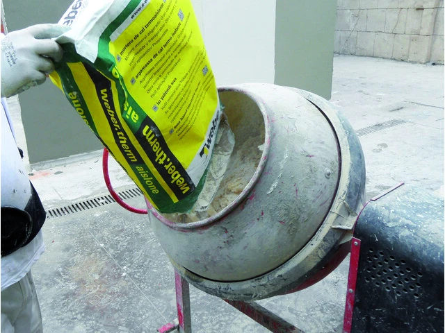 Hombre vertiendo saco en la hormigonera