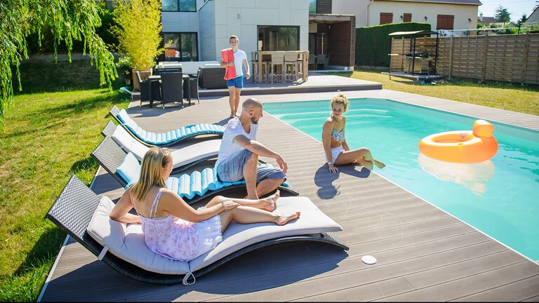 Exterior de una casa con piscina y familia