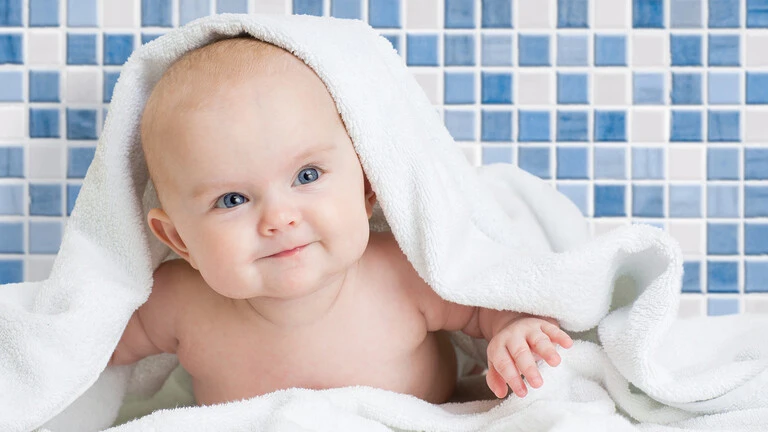 Bebe en un baño con pared de gresite