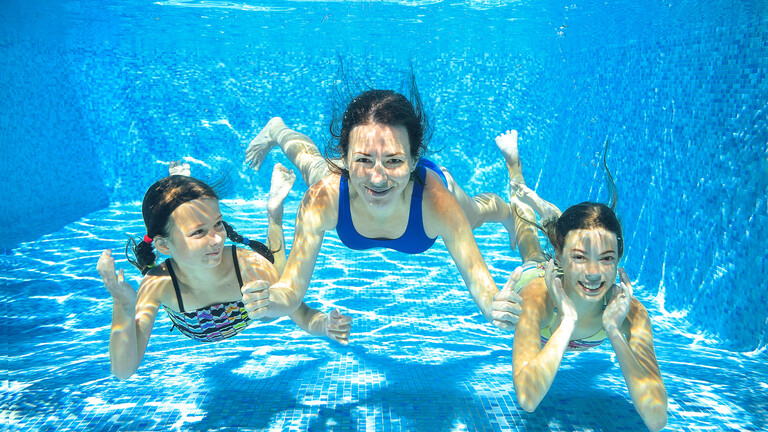 Familia buceando en la piscina Familia buceando en la piscina