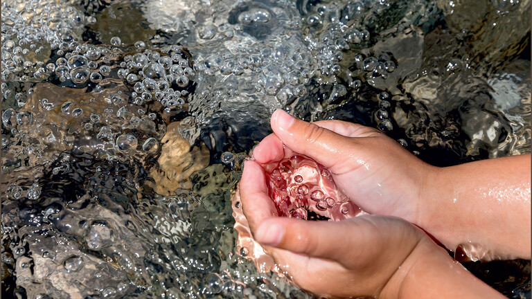 Manos de un niño cogiendo agua en el río Manos de un niño cogiendo agua en el río