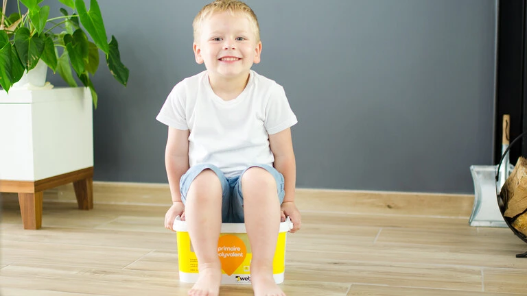 Niño sentado encima de un bidón de producto