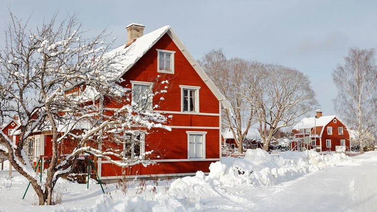 Casa de color roja con nieve alrededor